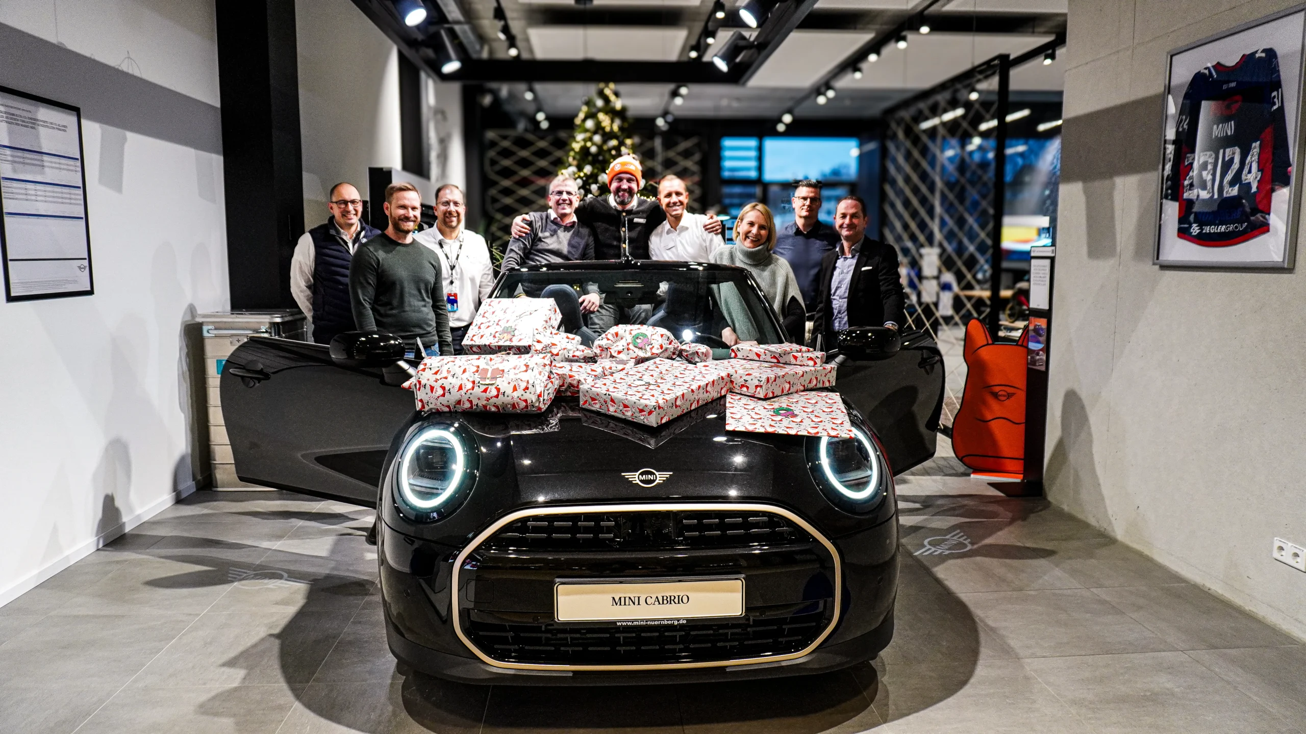 Weihnachtlich dekoriertes Auto von BMW mit lachenden Menschen dahinter